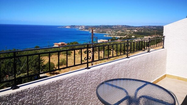 A balcony with a clear view of the sea and distant landscape. - Ocean Front Studios (Kefalonia)