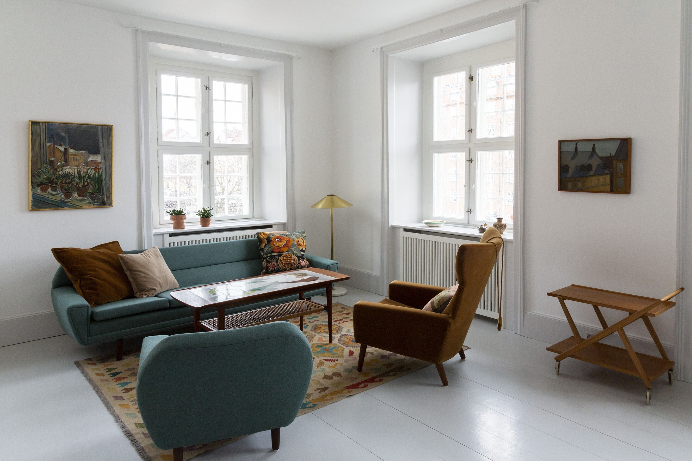 Un salon comprenant un canapé, un fauteuil, une table basse et une petite table d’appoint en bois.
