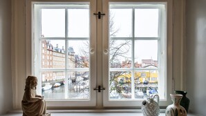 A room with a large window, a statue, and two vases on a windowsill. - Kanalhuset (Copenhagen)