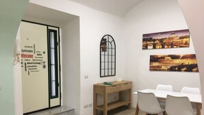 A room with a desk, chairs, and a view of a cityscape. - Casa Doria - Vatican Museums (Roma)