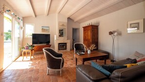 A living room with a fireplace, a television, and a large window.