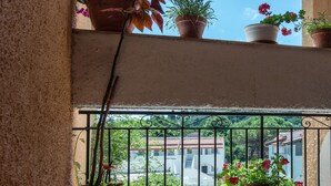 A balcony with potted plants and a view of buildings. - Lydia Apartment (Corfu)