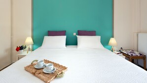 A hotel room with a large bed, two pillows, a tray with cups, and a small table with a lamp. - Lydia Apartment (Corfu)