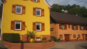 Un edificio giallo con molte finestre e un tetto marrone.