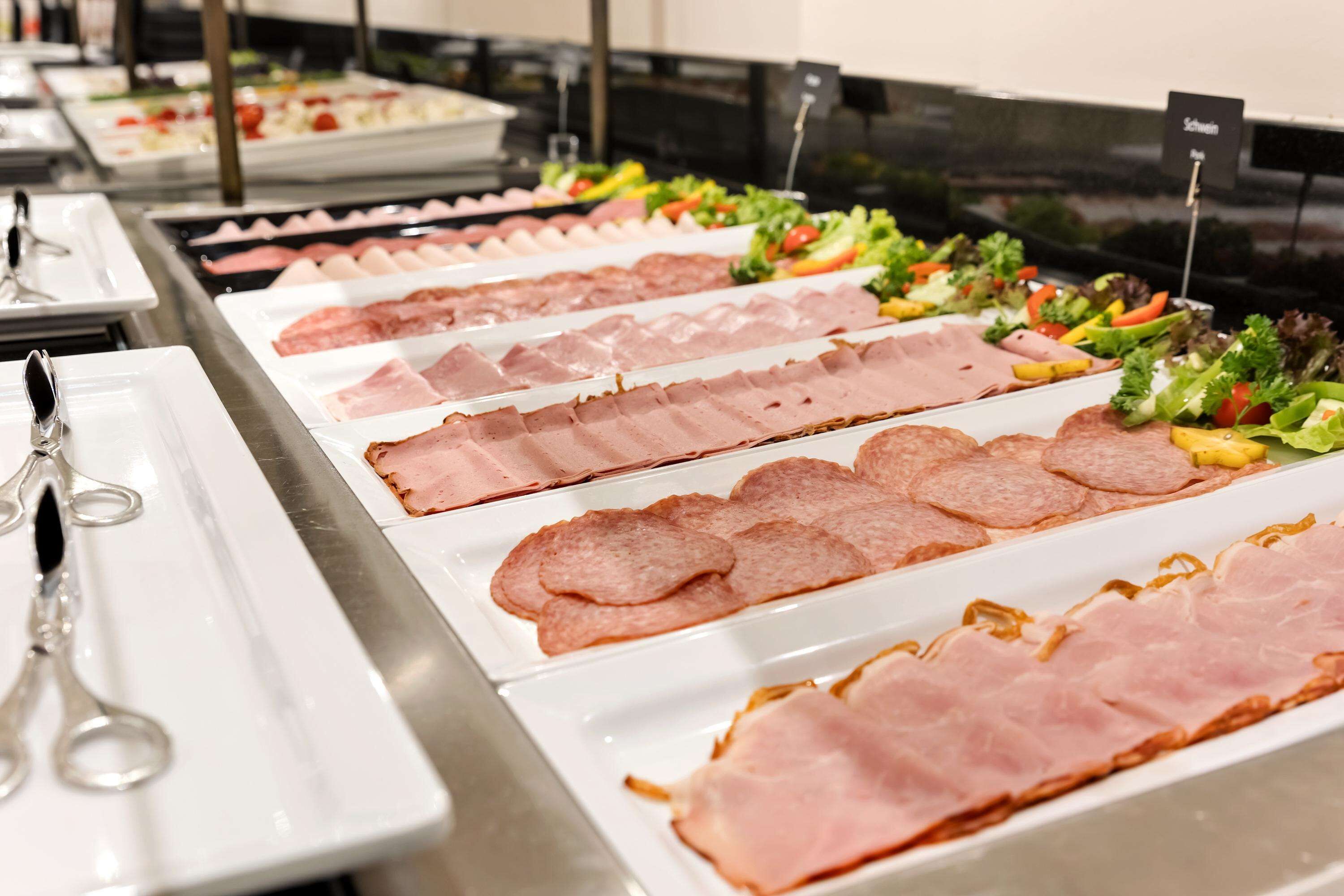 Een buffet met verschillende vleessoorten en salades.
