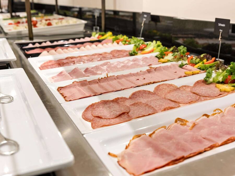 Een buffet met verschillende vleessoorten en salades.