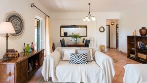 Een gezellige slaapkamer met een bed, nachtkastjes, een kaptafel, een spiegel en een kroonluchter.