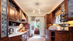 Een keuken met houten kastjes, een koffiezetapparaat en een schaal fruit.