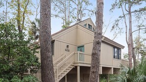 Une maison à deux étages avec un balcon et un escalier menant à l’étage supérieur.