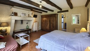 Camera da letto con un letto grande, un'armadio in legno e un tavolino con una lampada.