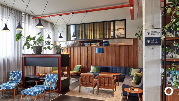Een moderne lounge met zitplaatsen, een open haard en een koffiebar.