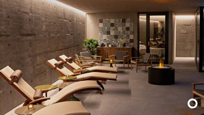 Un espace de détente moderne avec des fauteuils confortables, un petit foyer et un comptoir d’accueil.