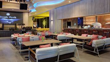 A modern restaurant interior with a stage, bar area, and seating arrangements.