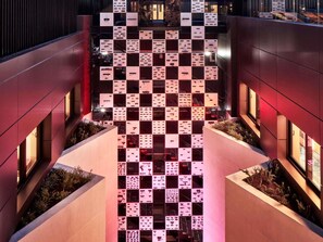 Un edificio moderno con un atrio central que presenta una cuadrícula de paneles cuadrados.