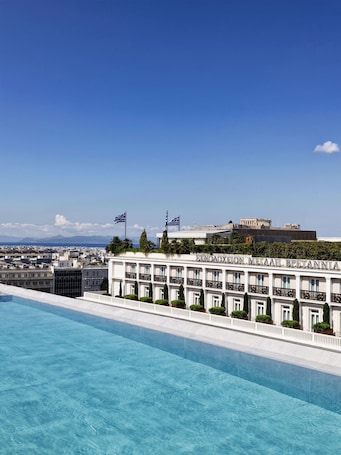 Una piscina al aire libre de temporada, sombrillas
