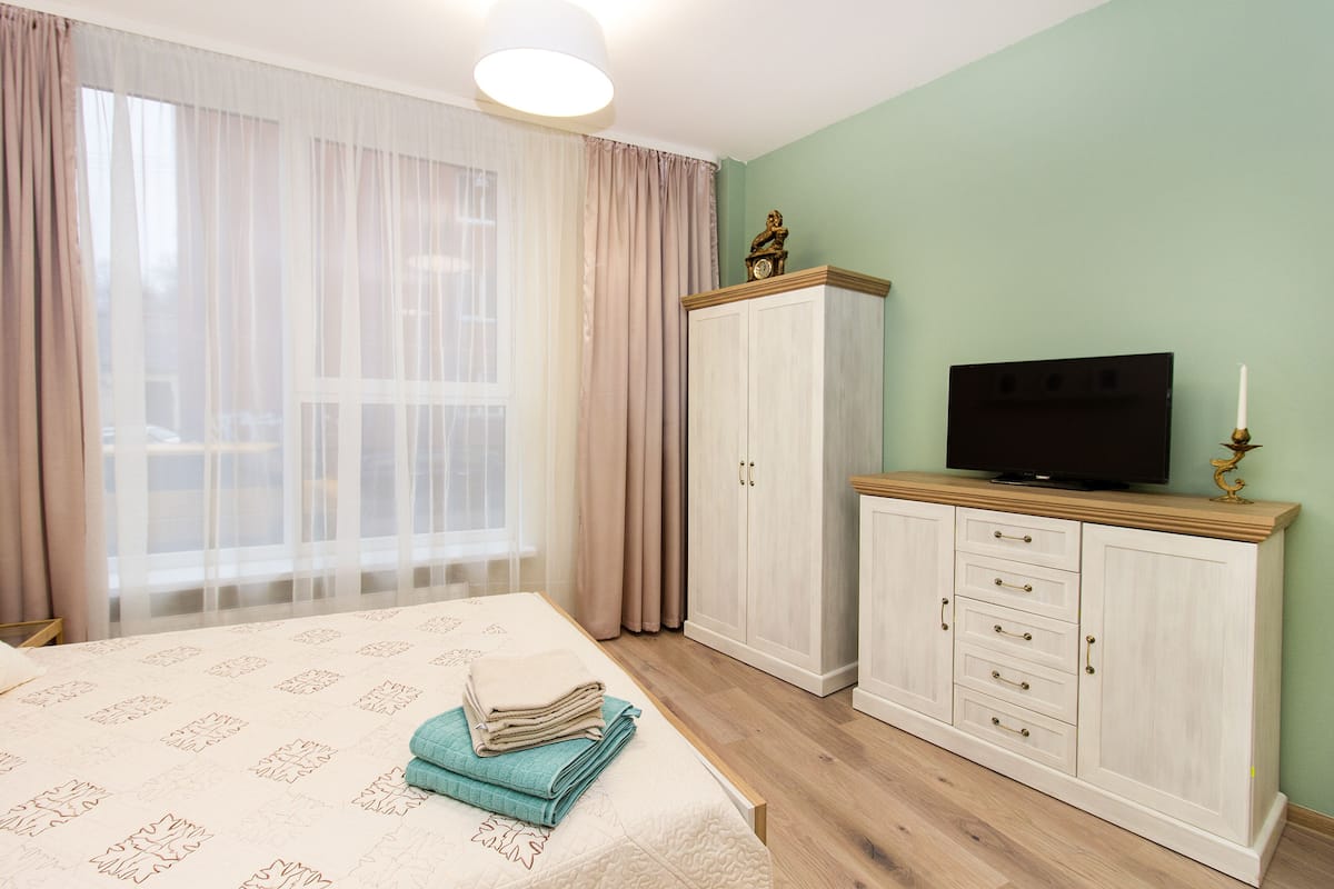 A bedroom with a bed, a TV, and a wardrobe.