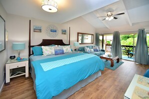 A bedroom with a large bed, a nightstand, a dresser, a chair, and a view of the outdoors.