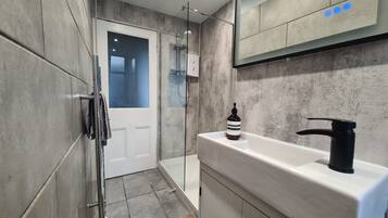 Een haardroger, handdoeken, zeep, toiletpapier