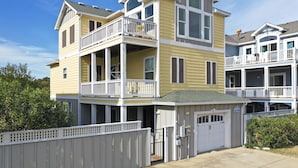 Un immeuble résidentiel à plusieurs étages doté d’un balcon, d’un garage et d’une entrée sécurisée par un portail.