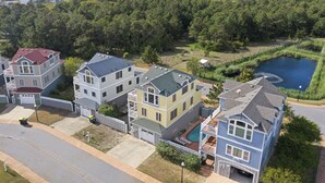 Un quartier résidentiel avec des maisons, une piscine et un plan d’eau en arrière-plan.