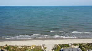 Une plage offrant une vue dégagée sur l’océan et bordée d’un rivage sablonneux.