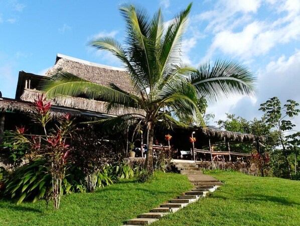 Traditional building surrounded by lush greenery and a well-maintained lawn, offering a serene environment.