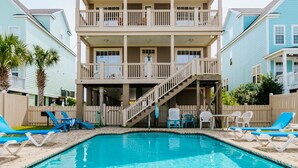 A two-story building with a balcony and a swimming pool in front. -  6 bedroom-5.5 bathrooms in the heart of Garden City Beach and Heated Pool (Murrells Inlet)