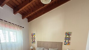 Ein Schlafzimmer mit einem großen Bett, einer Holzbalkendecke und zwei Nachttischen mit Lampen.