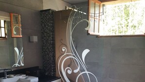 A bathroom with a modern design, featuring a large sink, a mirror, and a shower area with decorative glass panels. - Palavesa City (Porto-Vecchio)