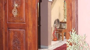 A wooden door with intricate carvings and a brass handle. - Riad la medersa in Marrakesch (Marrakech)