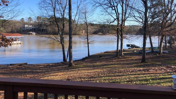 A lakeside view with a dock, trees, and a grassy area. - Charming 3BR 2BA Lakefront Lake Norman Home with Beach & Dock - Sleeps 10 (Sherrills Ford)
