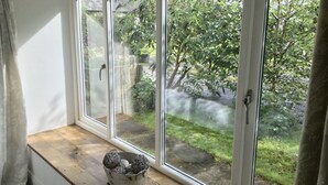 Una stanza con un'ampia finestra che si affaccia su un giardino.