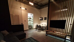 Una sala moderna con un sofá, una mesa de centro, un televisor y un comedor con sillas y una mesa.