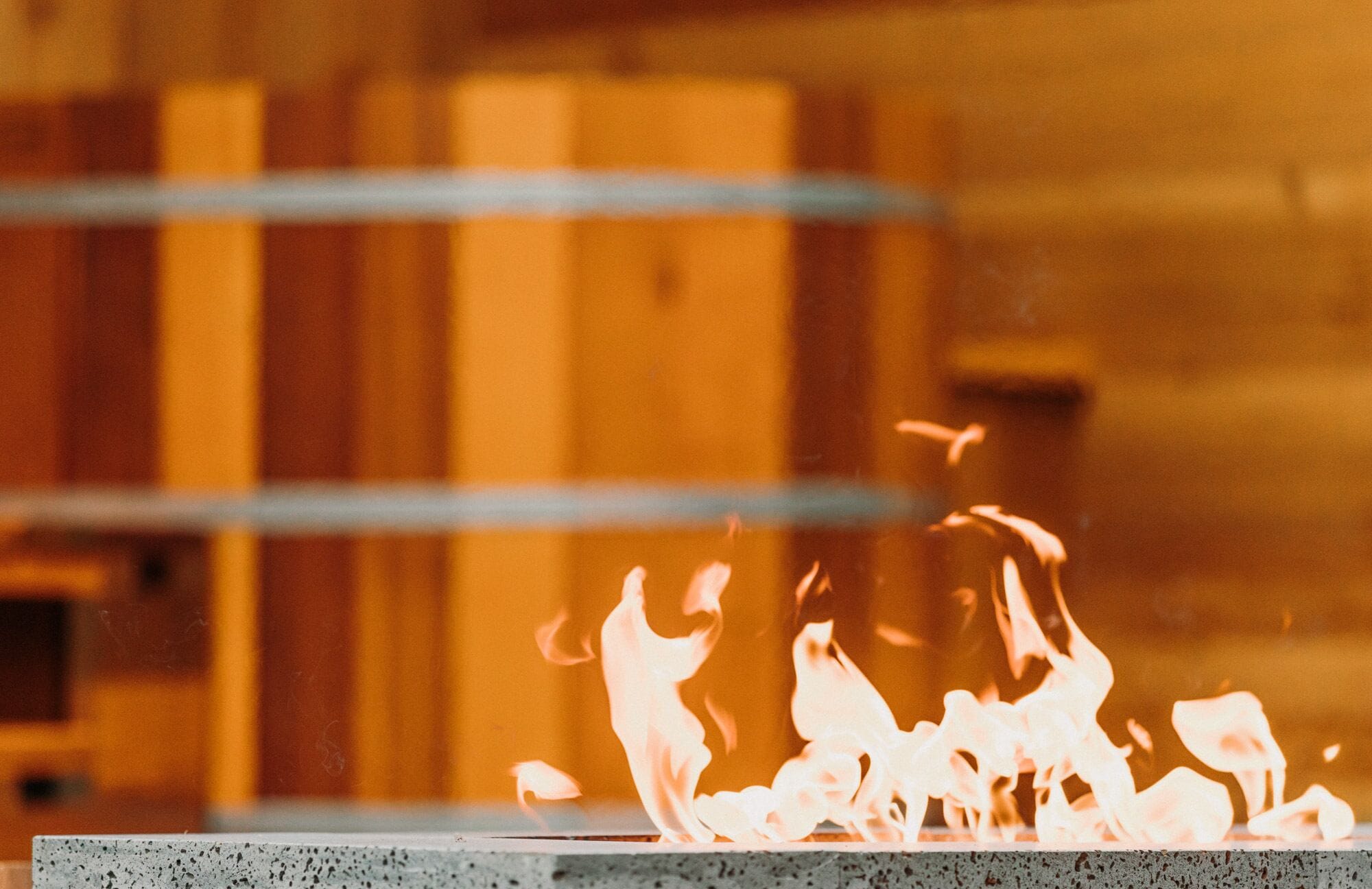 A close-up of a fire with flames dancing above a textured surface.