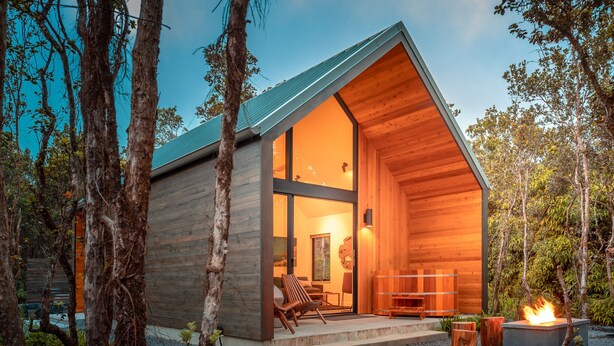 A modern wooden cabin with a large glass door, a fireplace, and a seating area. - Kuono at Volcano   . (Volcano)