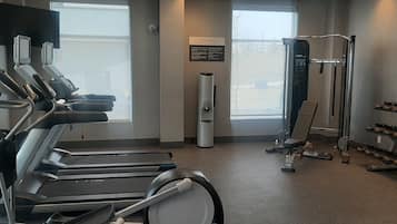A fitness center with treadmills, a weight machine, and a shoe rack.