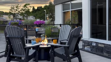 A patio with outdoor furniture and a fire feature.