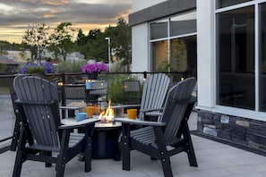 Un patio con mobiliario exterior y una chimenea.