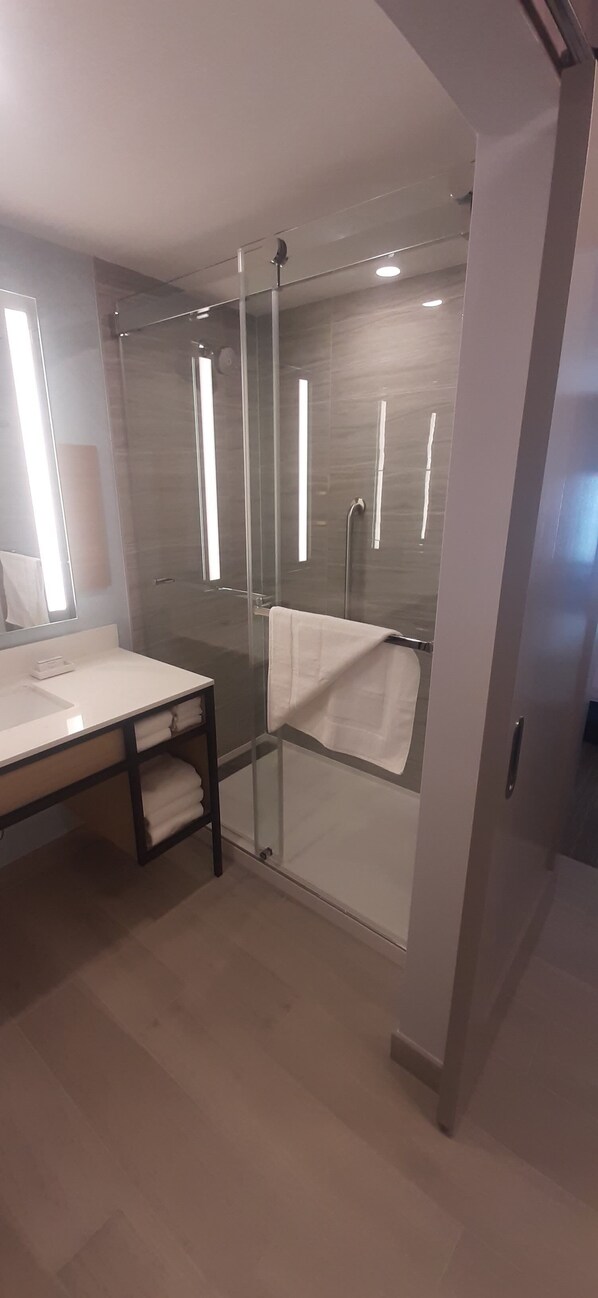 A modern bathroom with a glass-enclosed shower, a white sink, and a mirror. - Hilton Garden Inn Sudbury (Sudbury)