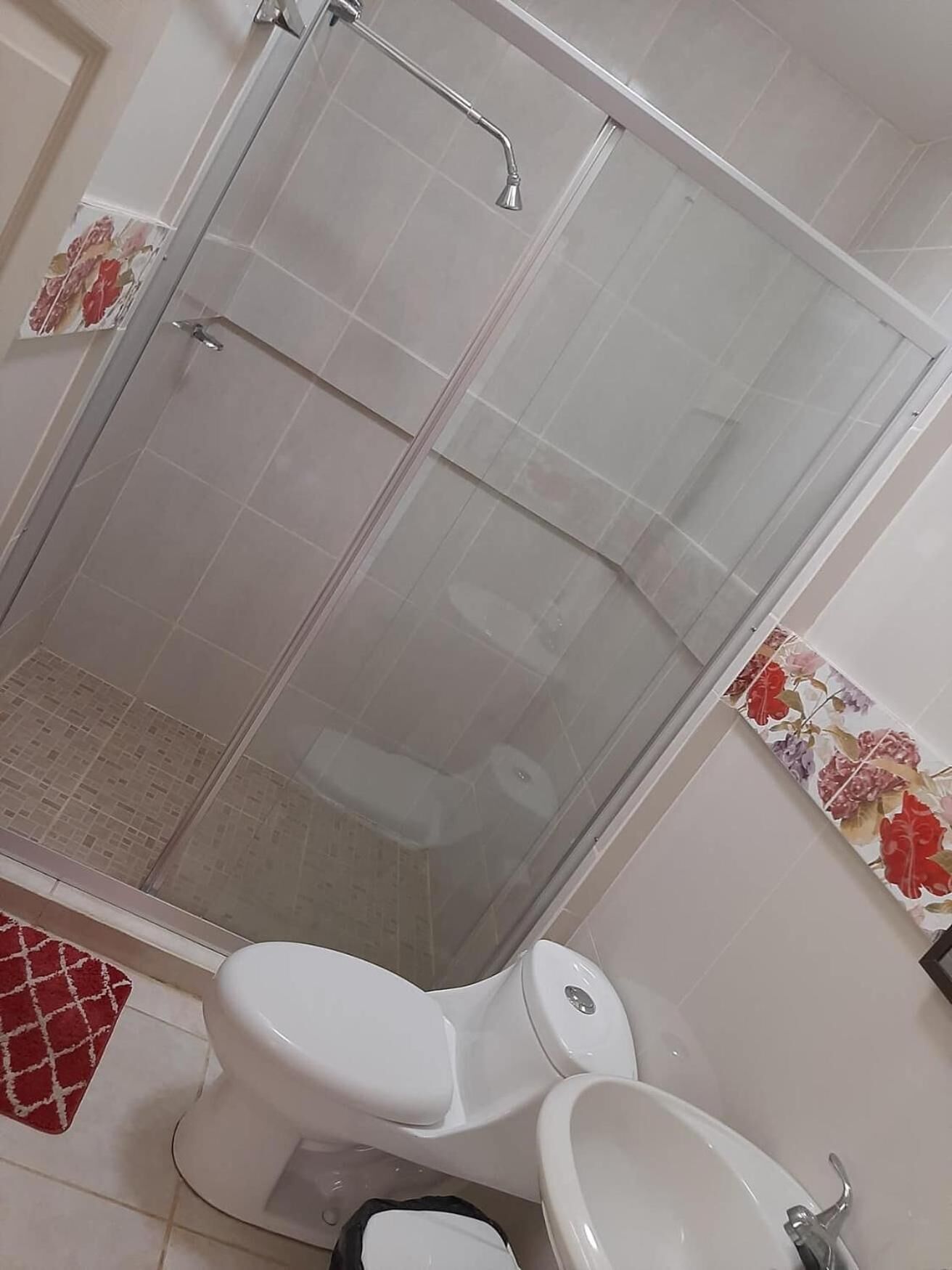 A bathroom with a glass-enclosed shower, a toilet, and a bidet.