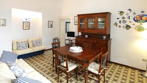 Una sala de estar con sofá, mesa de comedor y aparador.