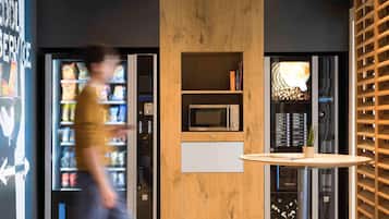 A modern interior with a vending machine, a microwave, and a small table.