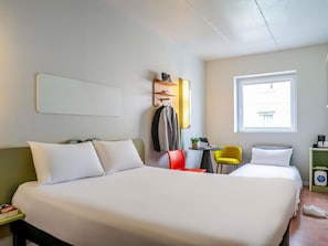 A hotel room with a large bed, a desk with a laptop, a chair, and a window. - Ibis Budget Bilbao Barakaldo (Barakaldo)