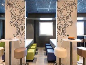 Un interior moderno con una zona de estar central, una ventana y un techo con diseño geométrico.