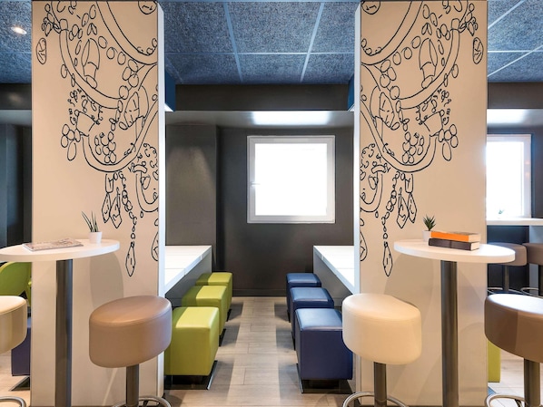 Un interior moderno con una zona de estar central, una ventana y un techo con diseño geométrico.