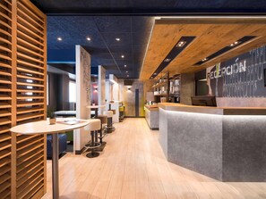 Un interior moderno con mostrador de recepción, separadores de madera listonada y un largo pasillo.
