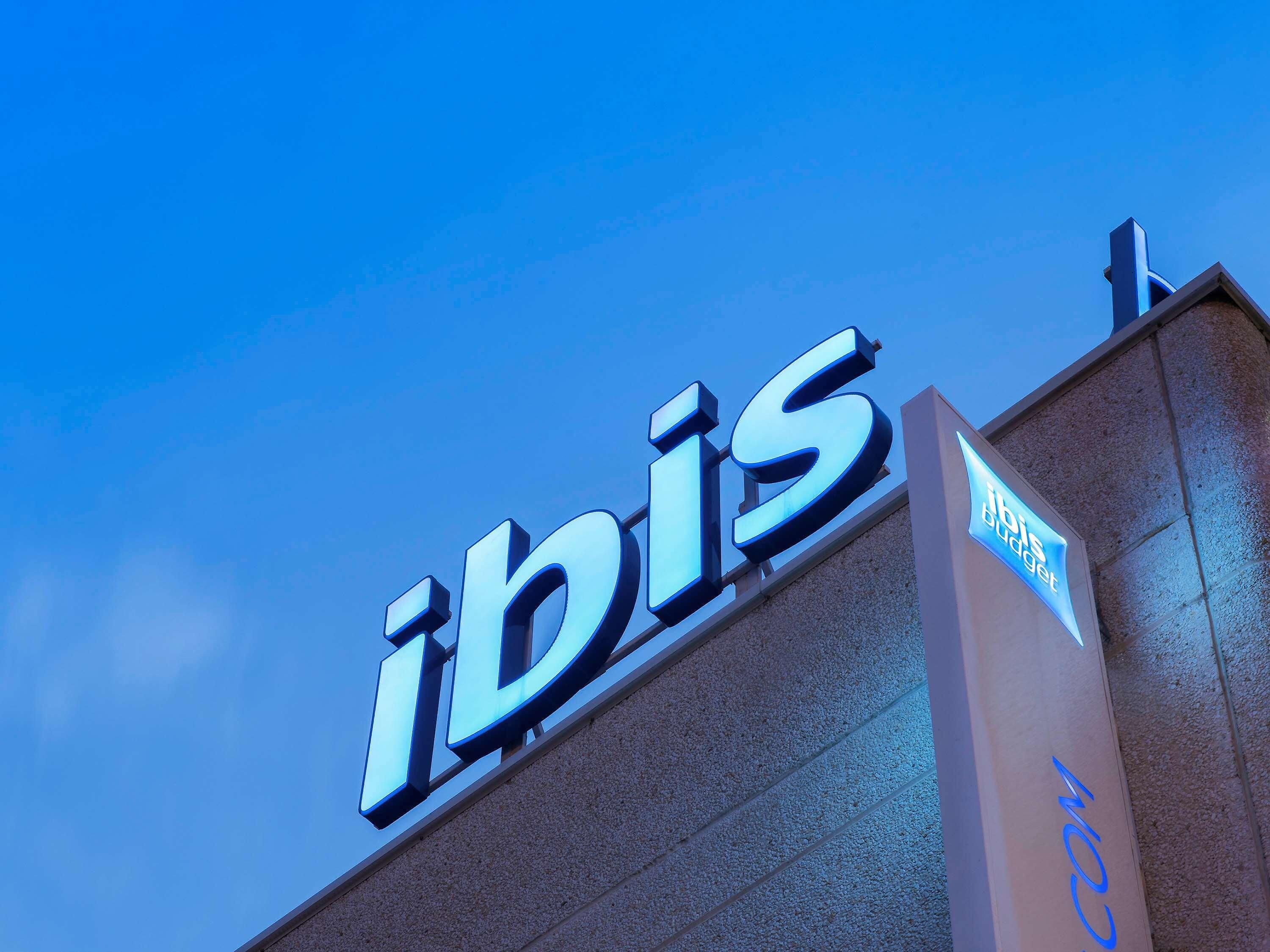 A building with a prominent 'ibis' sign, indicating it is a hotel.