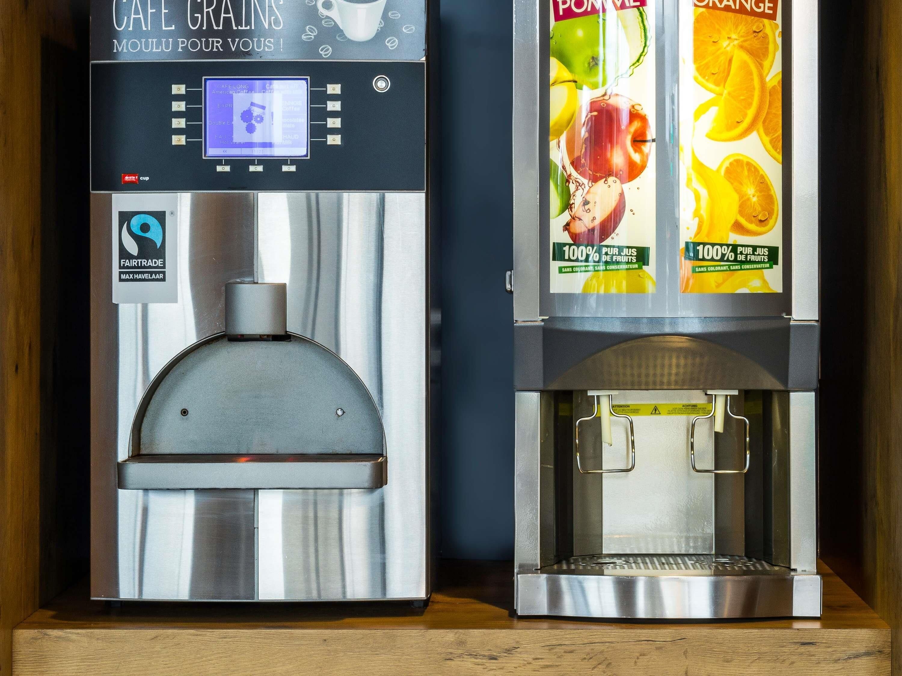 Dos máquinas de café con pantallas digitales y etiquetas con motivos de frutas.