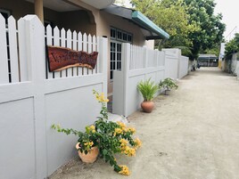 Uma entrada com portão e uma placa indicando "Northside Edge Inn". Há plantas em vasos ao longo do caminho.