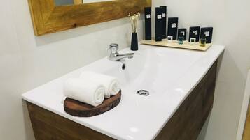A bathroom with a white sink, wooden vanity, and a mirror.